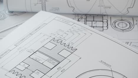 paper engineering drawings of industrial parts and mechanisms