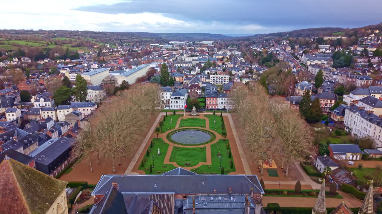 Saint-Pierre Cathedral and the formal Bishop's Garden, overlooking the city of Lisieux in Normandy, France. Aerial backward tilt-up reveal