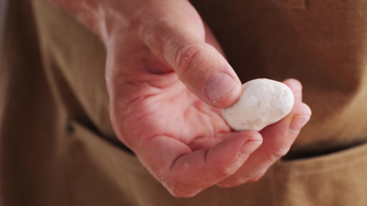 Close-up of Hand Gently Shaping Small White Dough Ball