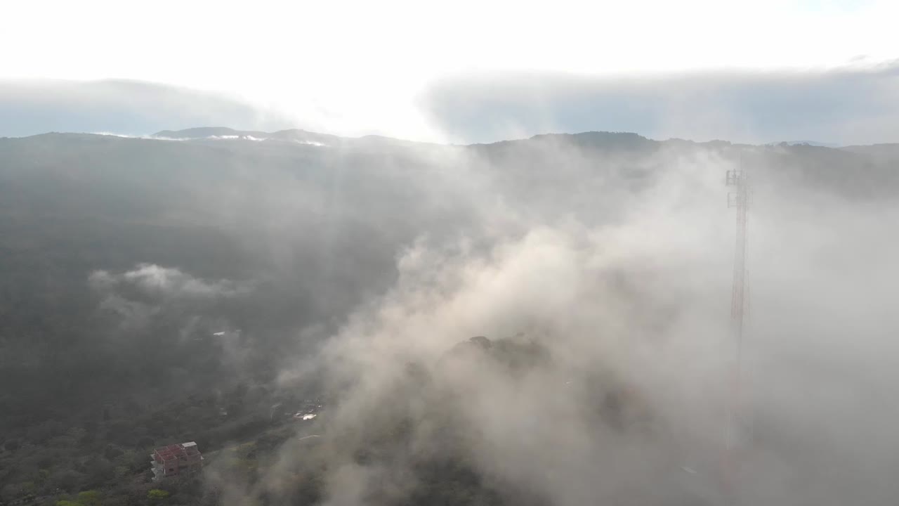 흐린 아침에 통신 안테나로 안개를 가로질러 전선을 당깁니다.