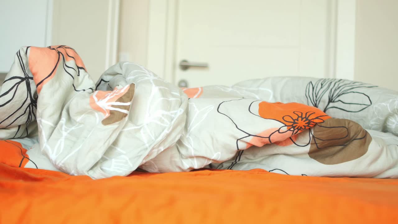 Scena accogliente di una camera da letto con lenzuola arancioni e biancheria da letto a fiori
