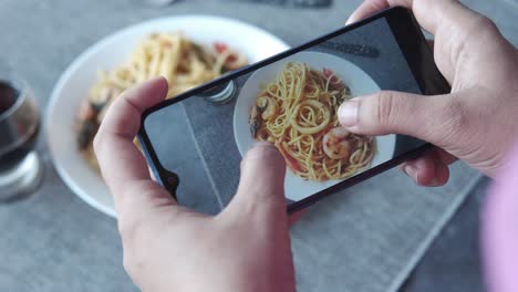 taking a photo of delicious spaghetti with seafood