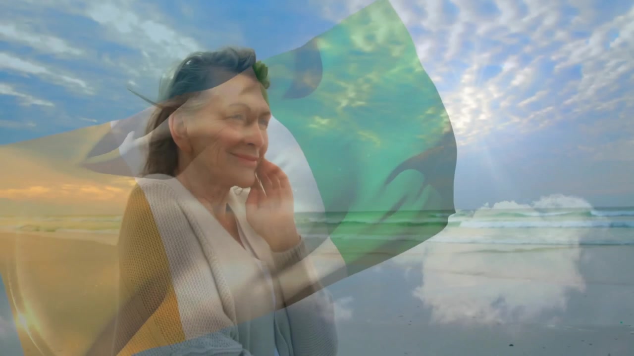 Senhora reagindo à brisa da praia, ajustando o cabelo sob uma sobreposição de bandeira transparente em um anúncio de viagem.