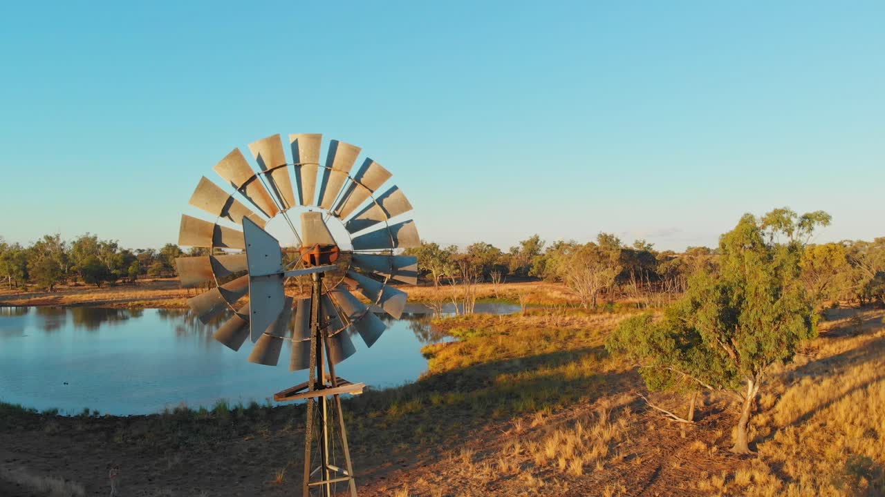 Windmill by a pond at sunset in Emerald, Queensland, Australia