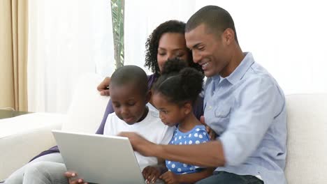 Familia-Afroamericana-Usando-Una-Computadora-Portátil-En-El-Sofá