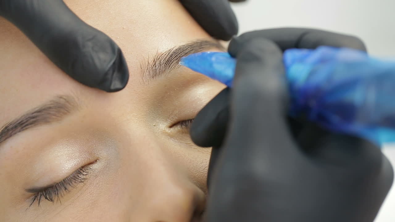 Permanent Tattooing Of Eyebrows. Cosmetologist applying permanent make up on eyebrows
