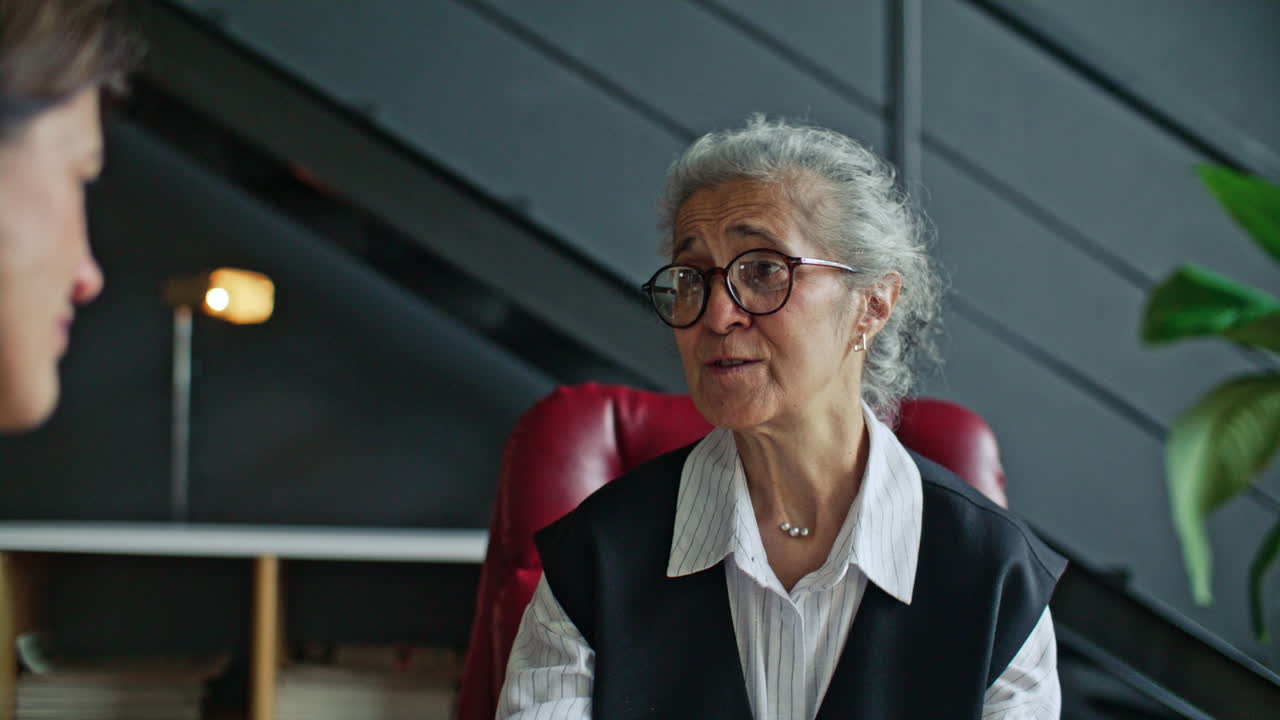 Terapeuta senior empatico che tiene le mani del paziente durante la consultazione