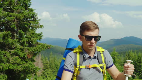 un joven turista sube a la montaña usa bastones de trekking en el contexto de un pintoresco s