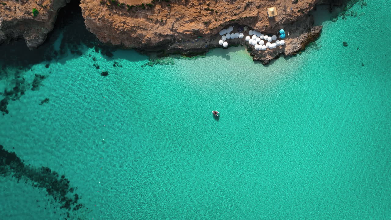 un pequeño bote remando en el agua azul clara en la laguna azul en la isla de comino en malta