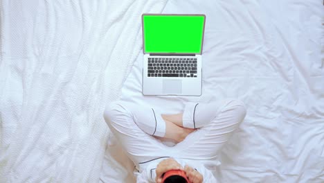 above view female holding red cup looking on display computer sits in bedroom