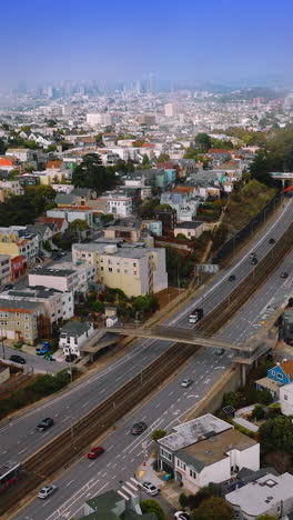 sunny city with beautiful architecture at daytime. transport moving by the motorways. aerial perspective. vertical video