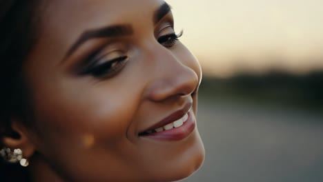 a beautiful woman with long brown hair smiles happily at the camera