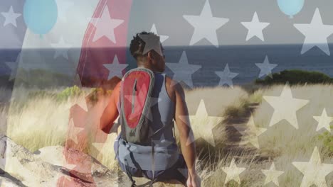 animation of american flag over african american man sitting in mountains