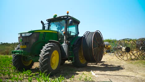 un tractor agrícola está parado con rodillos de goteo, antes de esparcir los goteos en el campo