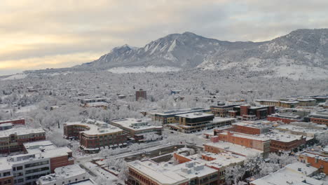 Ein-Niedriger-Drohnenschuss-Bewegt-Sich-Vorwärts-Von-Boulder-Colorado,-Rocky-Flatiron-Mountains-Und-Pearl-Street,-Nachdem-Ein-Großer-Winterschneesturm-Bäume,-Häuser,-Straßen-Und-Die-Nachbarschaft-In-Frischem-Weißem-Schnee-Bedeckt