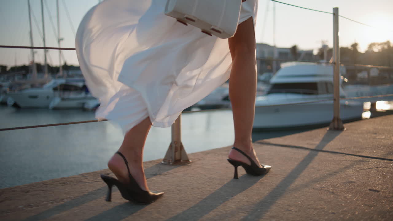 mujer caminando por un muelle con un vestido blanco