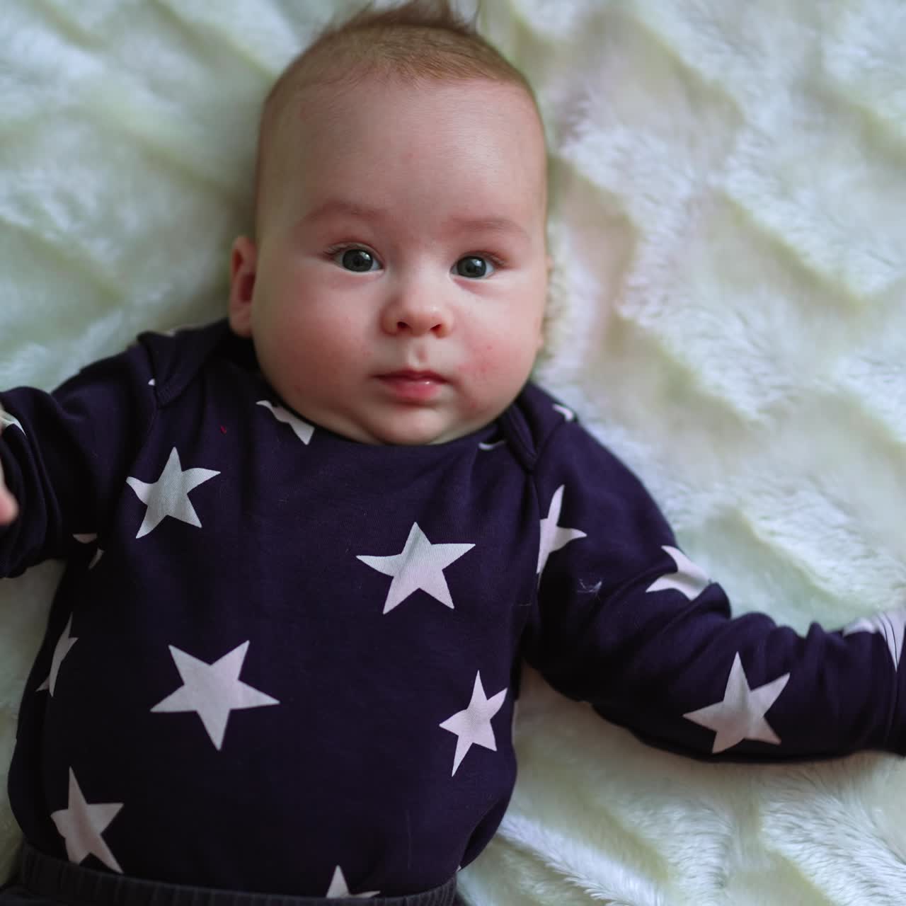 Cute small newborn boy. Gorgeous little baby lies on the bed