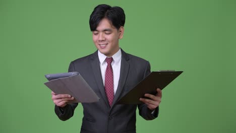 young handsome asian businessman using digital tablet