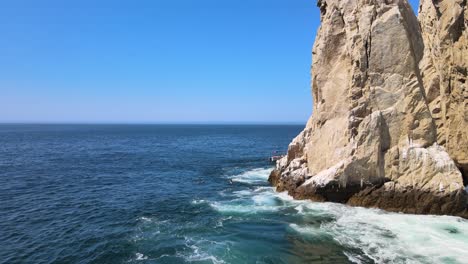 Lovers-beach-in-Los-Cabos,-aerial-view-over-the-ocean-showing-the-rocky-shoreline