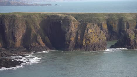 Vista-Espectacular-De-Los-Acantilados-Que-Rompen-Las-Olas-Cerca-Del-Castillo-De-Dunnottar,-Escocia,-Capturando-El-Poder-Puro-De-La-Naturaleza