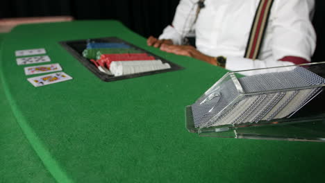 Poker-game-dealer-dealing-the-flop-card-from-dispenser-in-a-casino-at-a-black-jack-table