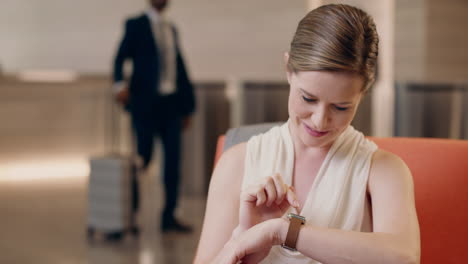mujer de negocios caucásica usando reloj inteligente en la recepción de negocios