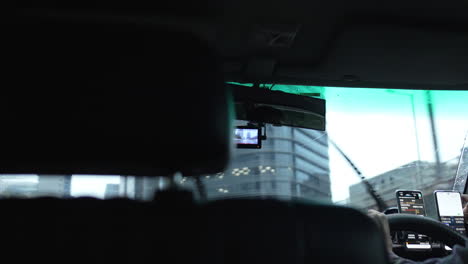 driving around by car during rain with windscreen wiper and panoramic cityscape of central modern skyline city with skyscrapers