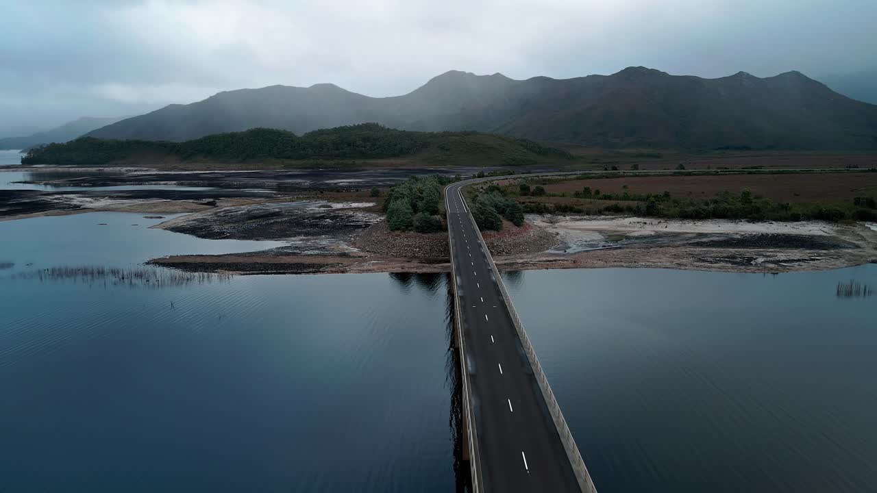 오스트레일리아 태즈매니아의 아름다운 풍경과 전면에 있는 다리가 있는 버버리 호수 (lake burbury) 의 역전 드론.