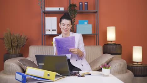 Home-office-worker-young-woman-looking-at-paperwork-files.