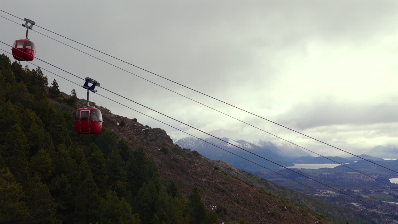 Gondola della funivia in viaggio sopra un pendio boscoso al Cerro Otto, San Carlos de Bariloche, Argentina.