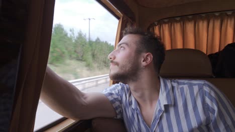 Young-man-looking-out-from-inside-the-vehicle.