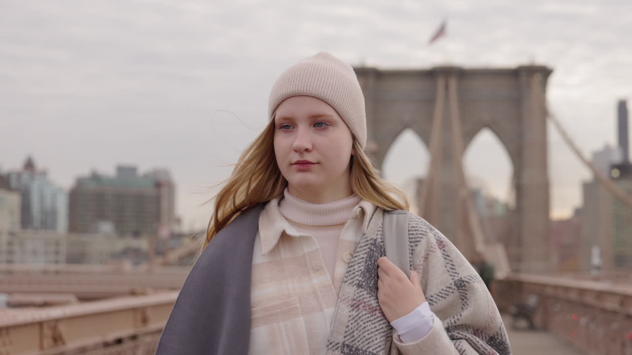 Giovane donna che cammina sul Ponte di Brooklyn a New York
