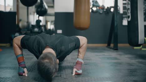hombre haciendo flexiones en el gimnasio de boxeo