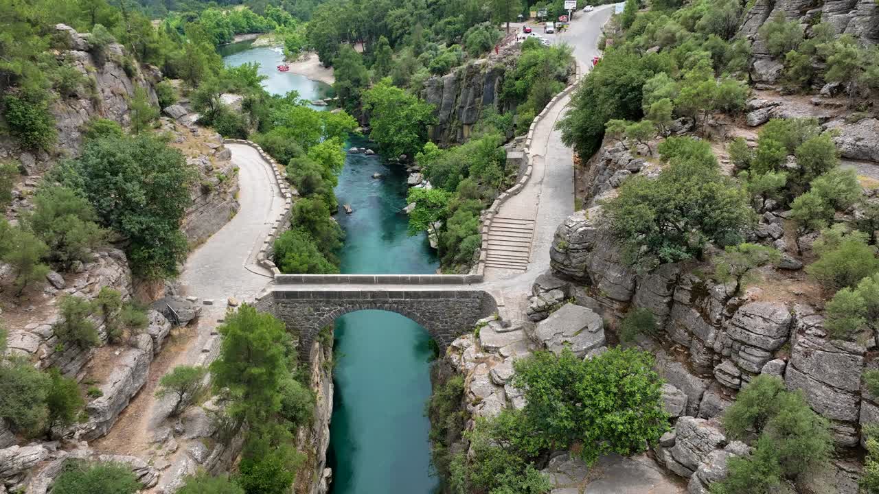 Vista aerea di un ponte ad arco in pietra su un fiume turchese in un canyon