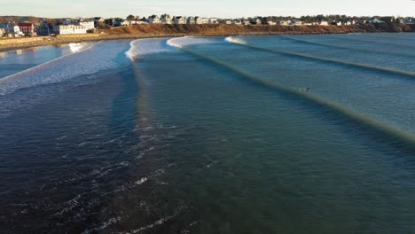 Imágenes-Aéreas-Siguiendo-Las-Olas-En-La-Costa-En-York-Beach-Maine-En-Una-Mañana-Fría-Y-Ventosa-De-Diciembre-Con-Casas-De-Playa-En-La-Distancia