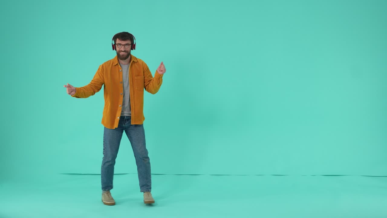 un hombre alegre con auriculares moviéndose al ritmo de la música