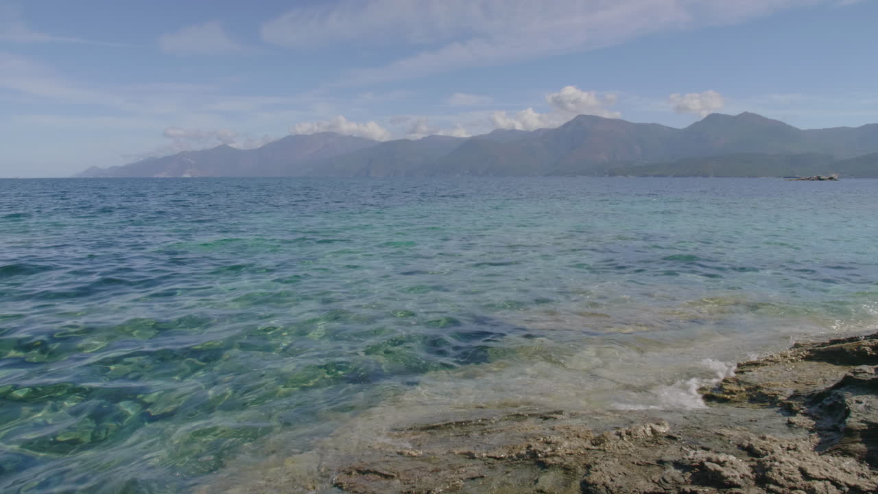 Saint-Florent Corsica coast sunny view of crystal clear turquoise waters, rocky shorelines under a bright blue sky serene Mediterranean landscape untouched natural beauty northern Corsican seaside
