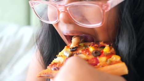 una chica comiendo pizza.