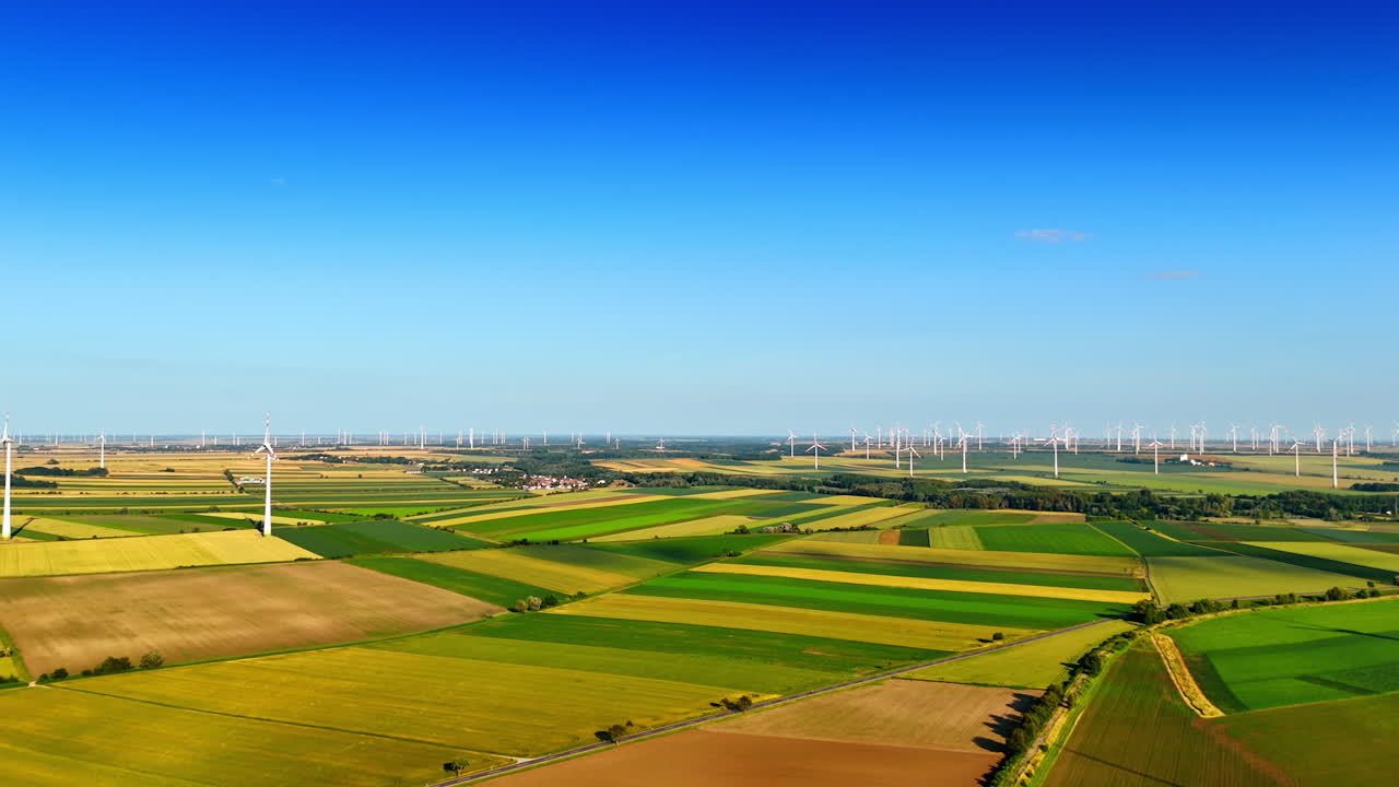Turbines create clean energy. Wind turbines stand tall among lush green fields, showcasing sustainable energy production in a rural landscape