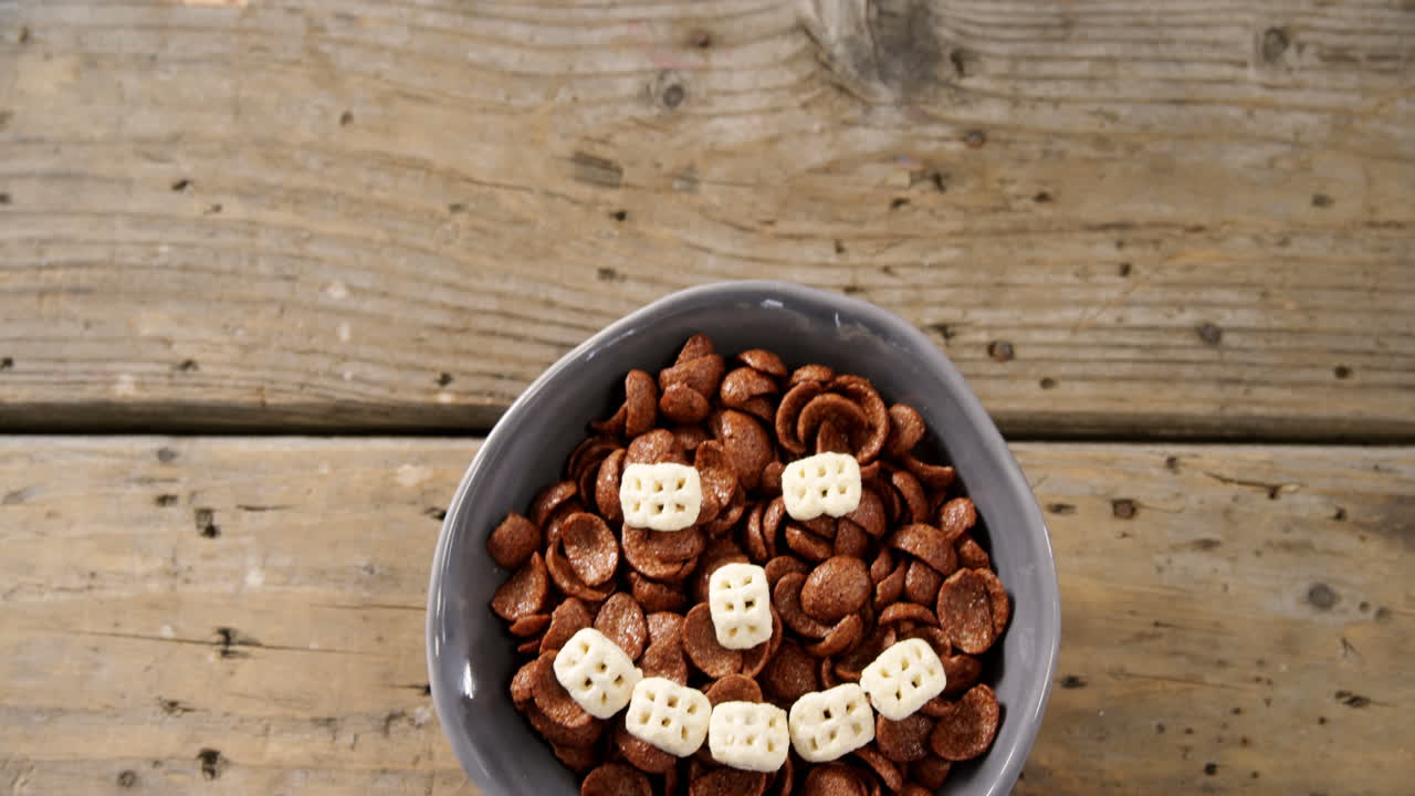 copos de maíz de chocolate con cereal de panal de miel que forman una cara sonriente en un cuenco 4k