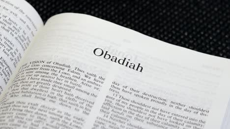 close up shot of bible page turning to the book of obadiah