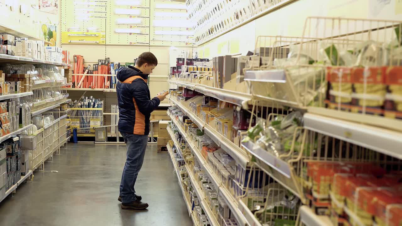 젊은 남자가 상점에서 전기 제품을 선택합니다.