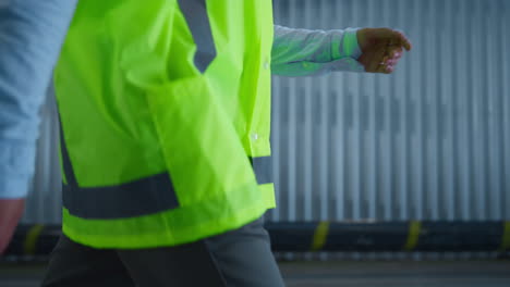 closeup factory worker walking at warehouse supply complex checking production