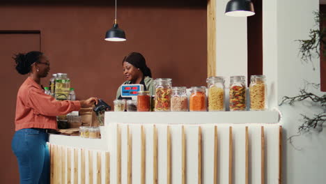 cliente que paga con tarjeta en la terminal postal para comprar alimentos biológicos