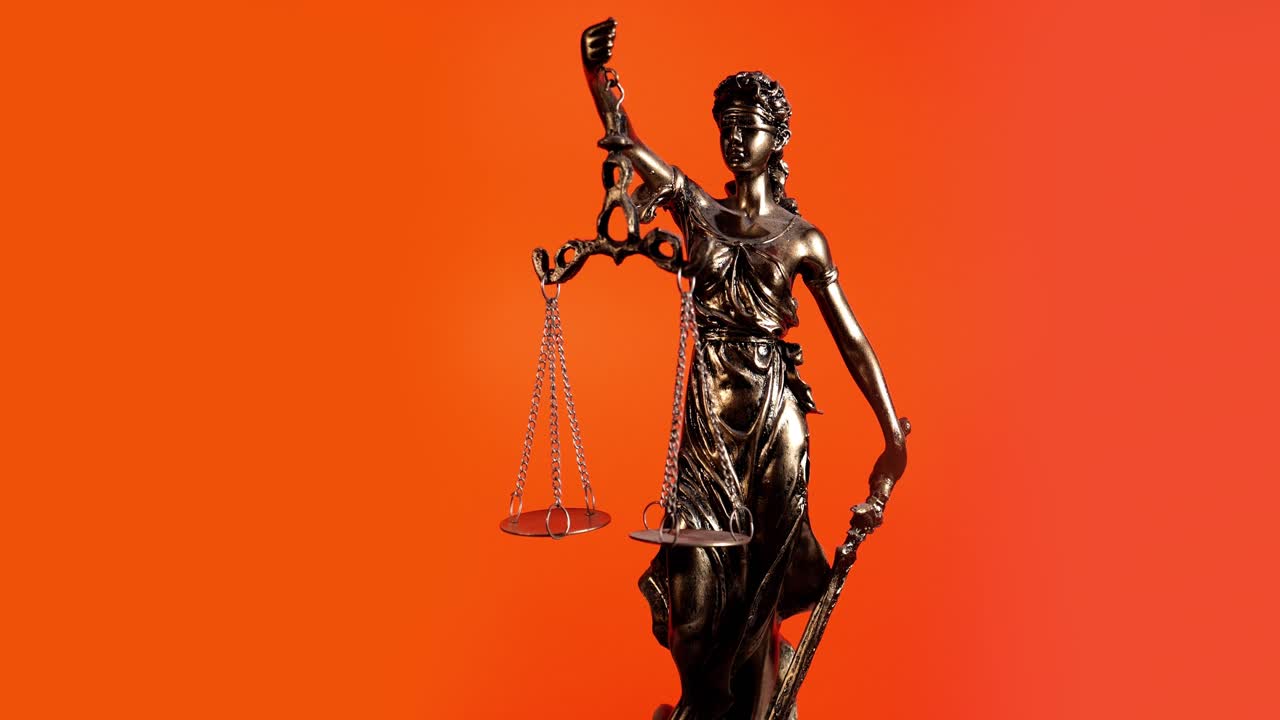 Statua della Giustizia in rotazione su sfondo arancione