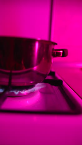 cooking pot on a gas stove with pink lighting