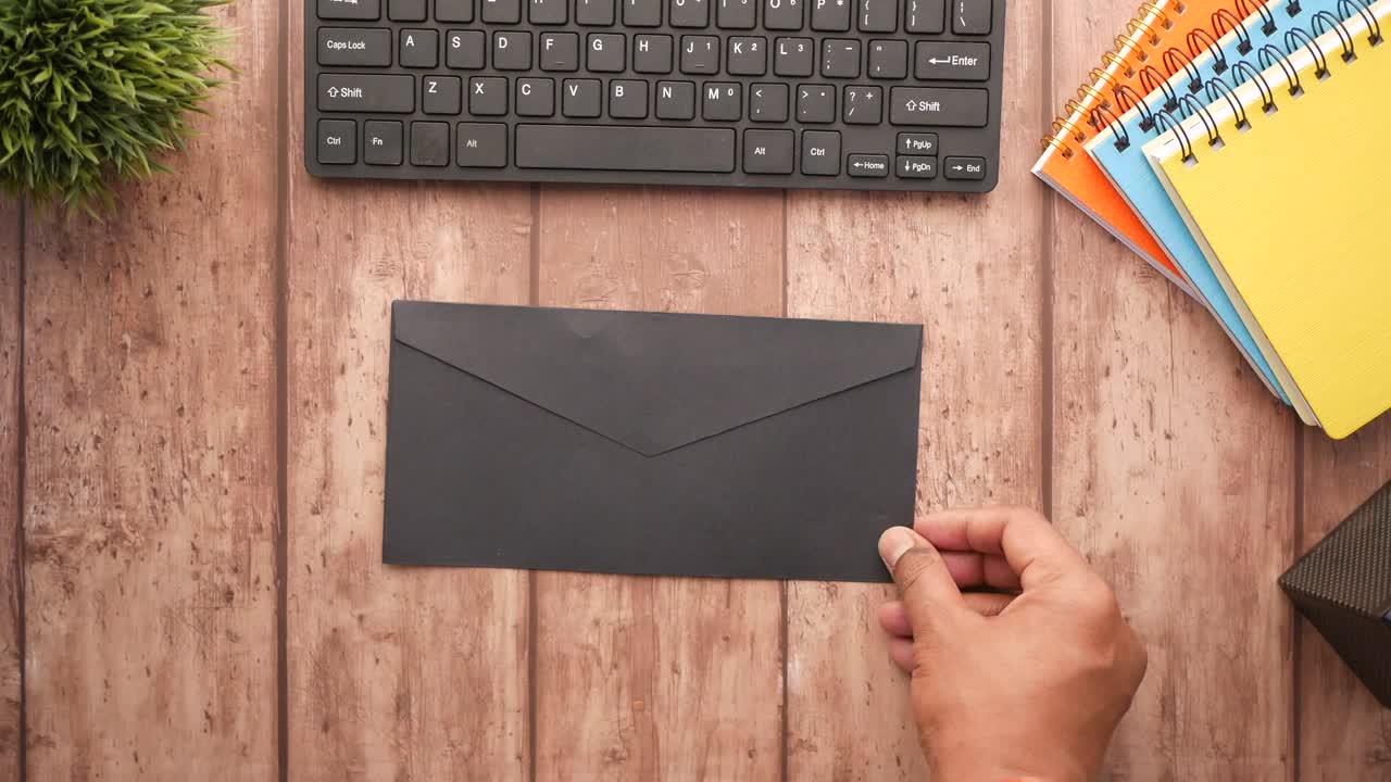 mano de la persona poniendo dinero en efectivo en un sobre.