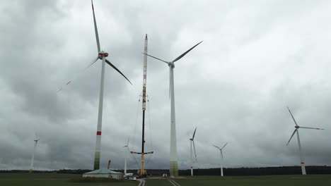 Bau-Von-Nachhaltiger-Energie:-Arbeiter-Und-Ein-Kran-Montieren-An-Einem-Bewölkten-Tag-In-Bad-Wünnenberg,-Paderborn,-Nordrhein-Westfalen,-Deutschland,-Eine-Windkraftanlage