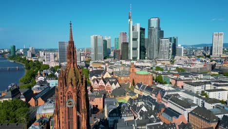 4k aerial drone video of the historic kaiserdom st. bartholomäus church on the banks of the main river in downtown frankfurt, germany
