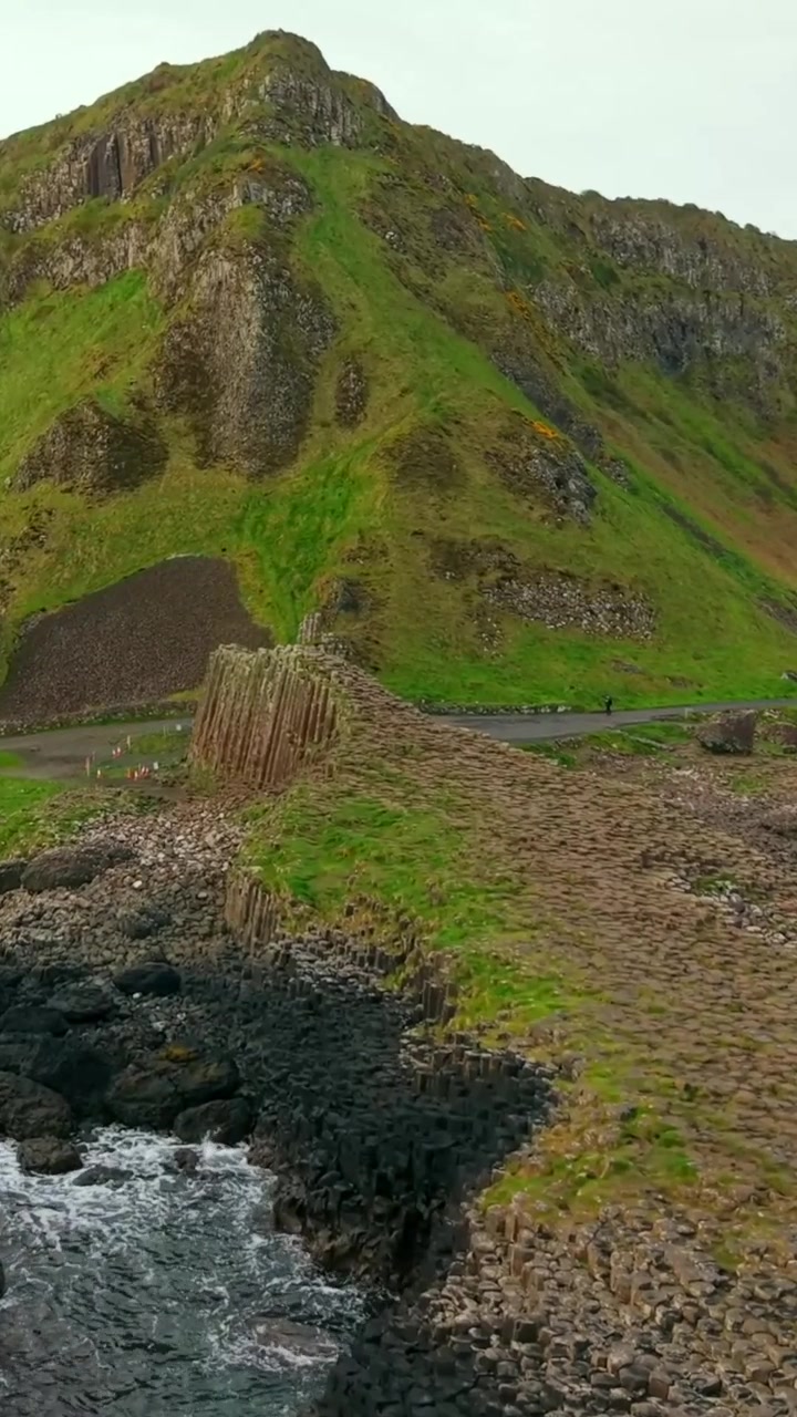 Video aereo in formato social che si avvicina al Selciato del Gigante a Bushmills, Contea di Antrim, nell'Irlanda del Nord, Regno Unito. Prodotto in formato verticale 1080x1920 con colore Rec709.